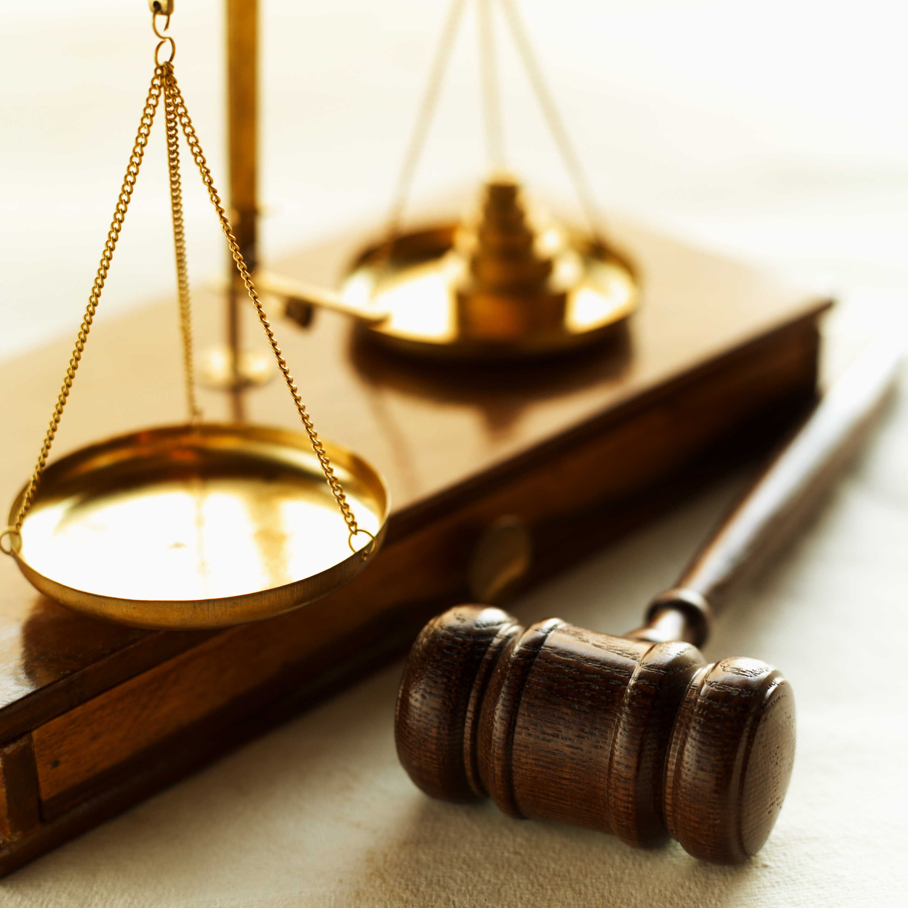 Close-up of weights balancing scales of justice with gavel beside it