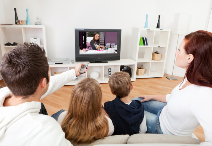 Young family watching TV at home