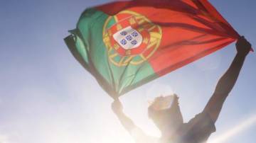 Homem segura bandeira de Portugal contra a luz