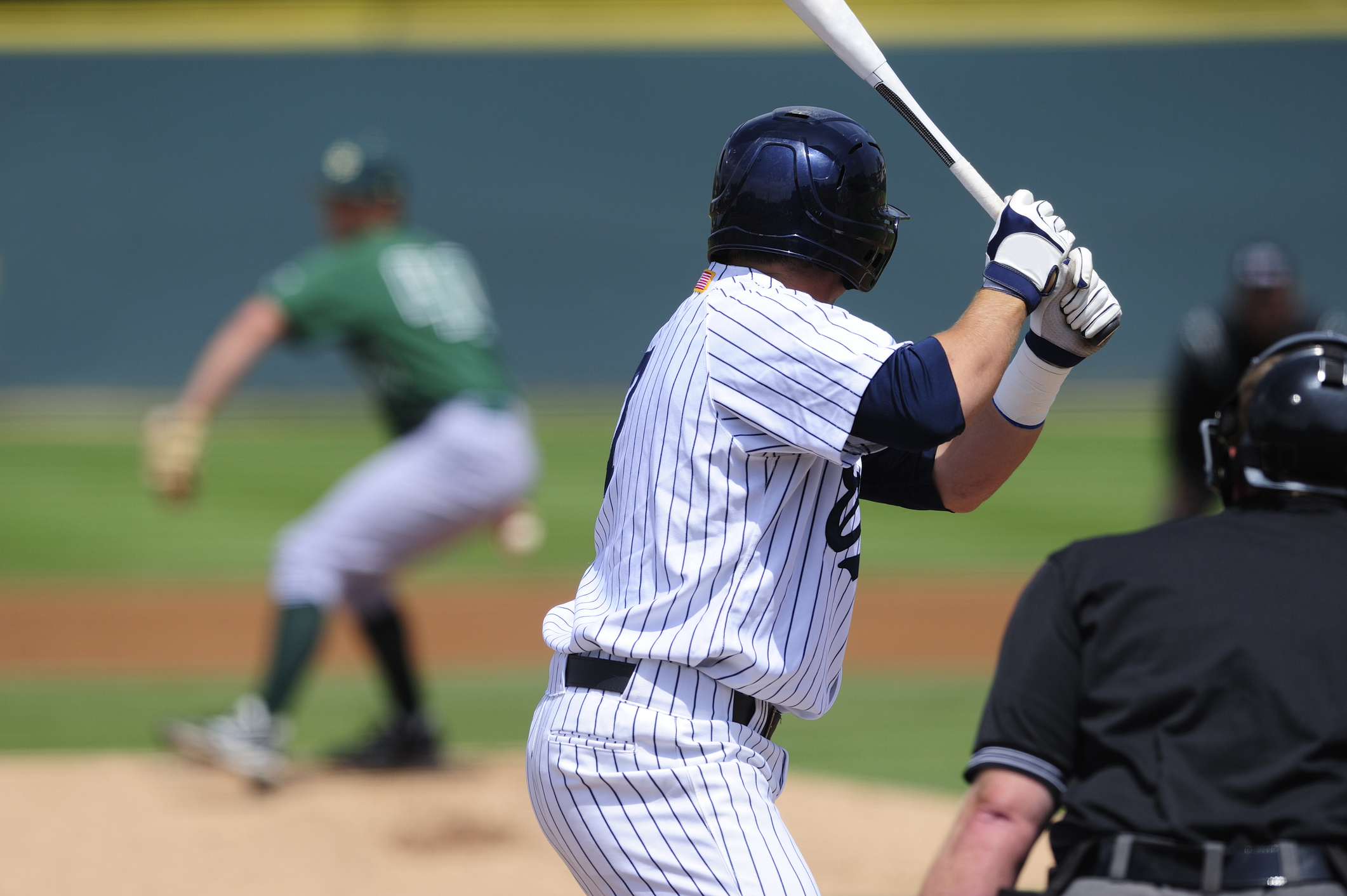 A baseball player looks at a pitch during a game.